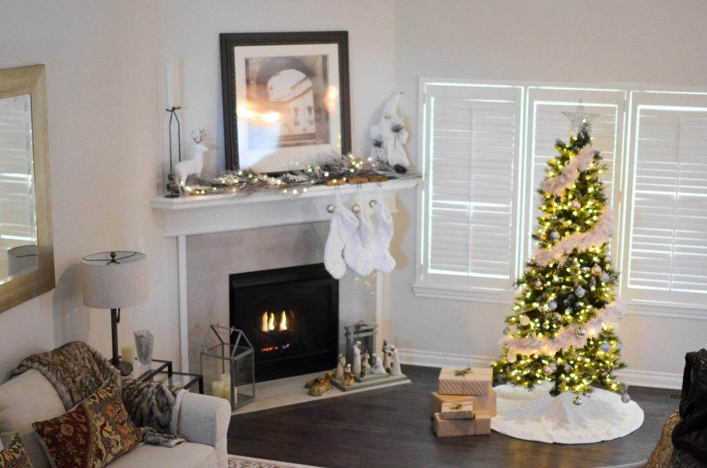 a lit fireplace and decorated christmas tree in a lounge