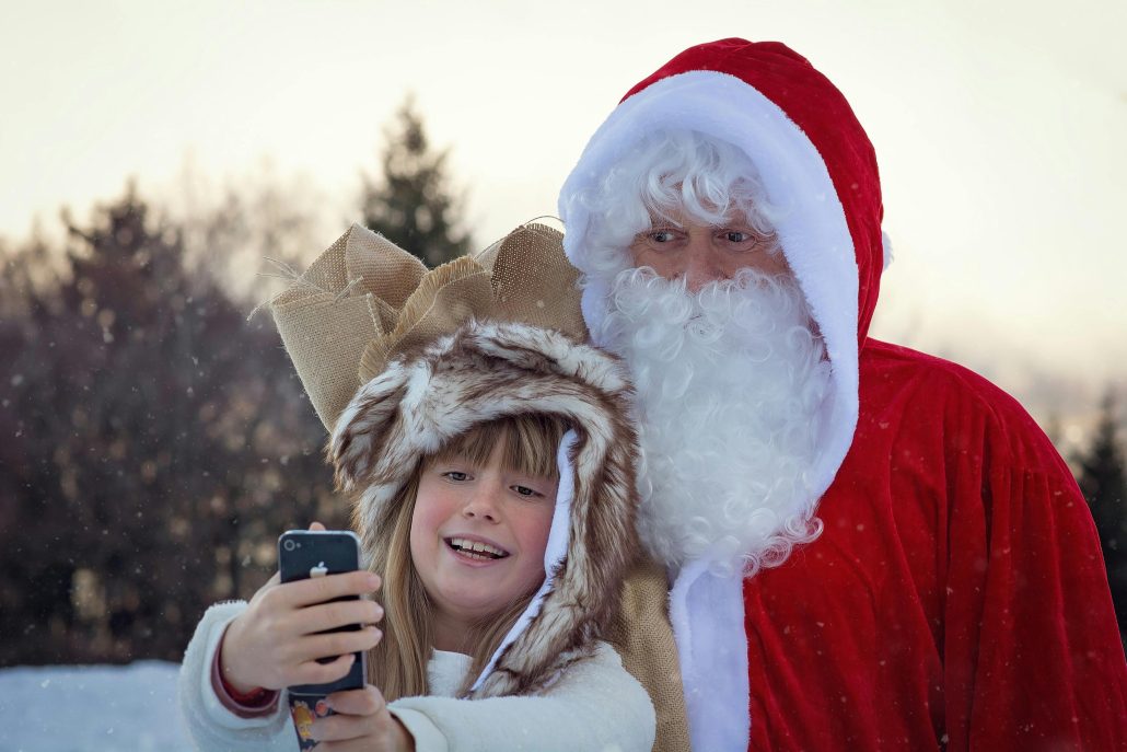 a kid taking a selfie with Santa