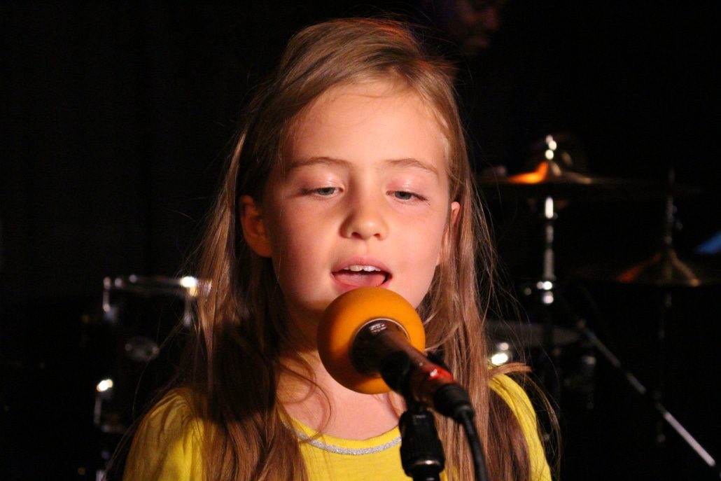 little girl singing into a microphone