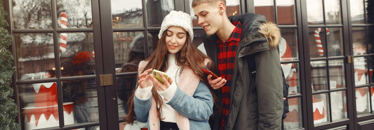 two teens looking at their phone during christmas